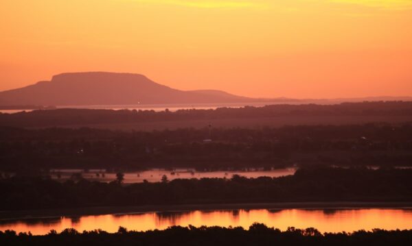 A Badacsony lassan kibontakozik a hajnali párából, közvetlen alatta a Balaton vize sejlik fel, míg lent Zalaszabari határában a Kis-Balaton.